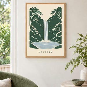K&ouml;nnte beinhalten: Ein gerahmter Kunstdruck mit einer stilisierten Illustration eines Wasserfalls, der in ein Becken st&uuml;rzt, umgeben von dunkelgr&uuml;nen B&auml;umen und Blattwerk. Der Hintergrund ist cremefarben und das Wort LEITRIM ist unten in Schwarz aufgedruckt.