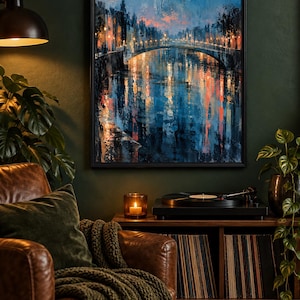 Op de afbeelding: Een ingelijste muurkunstprint met een stadsgrachtsc&egrave;ne bij schemering, inclusief een brug, gloeiende straatlantaarns en diepblauwe en oranje reflecties op het water. Het schilderij bevat dikke, getextureerde penseelstreken en een donker palet.