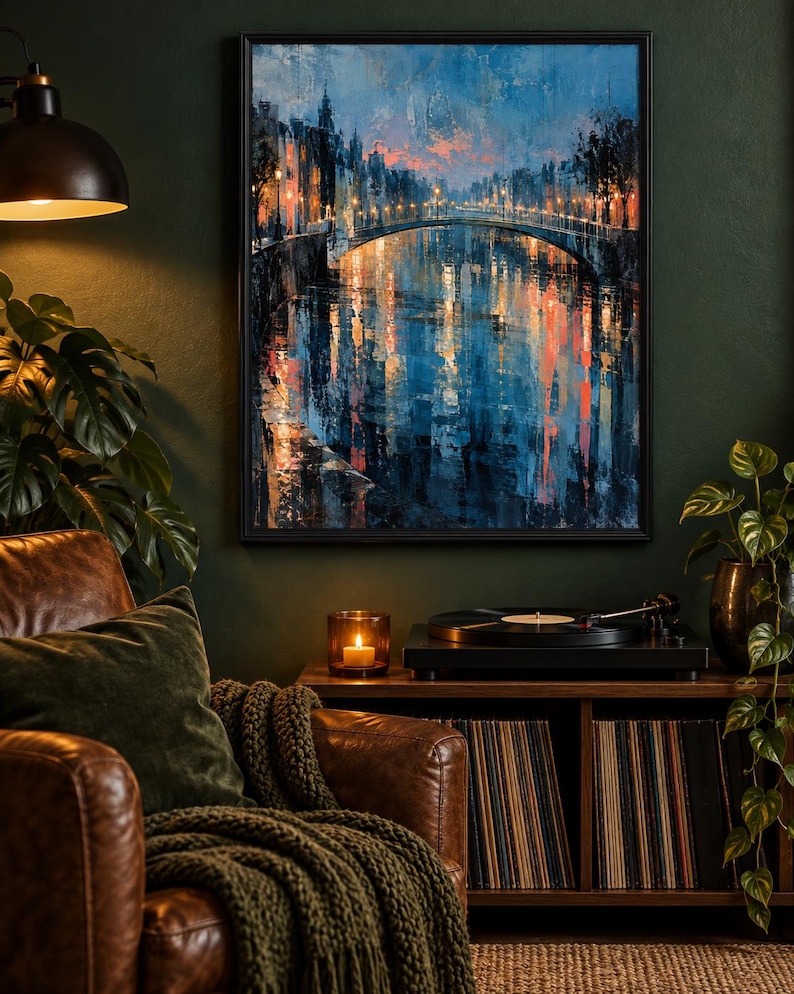 Op de afbeelding: Een ingelijste muurkunstprint met een stadsgrachtsc&egrave;ne bij schemering, inclusief een brug, gloeiende straatlantaarns en diepblauwe en oranje reflecties op het water. Het schilderij bevat dikke, getextureerde penseelstreken en een donker palet.