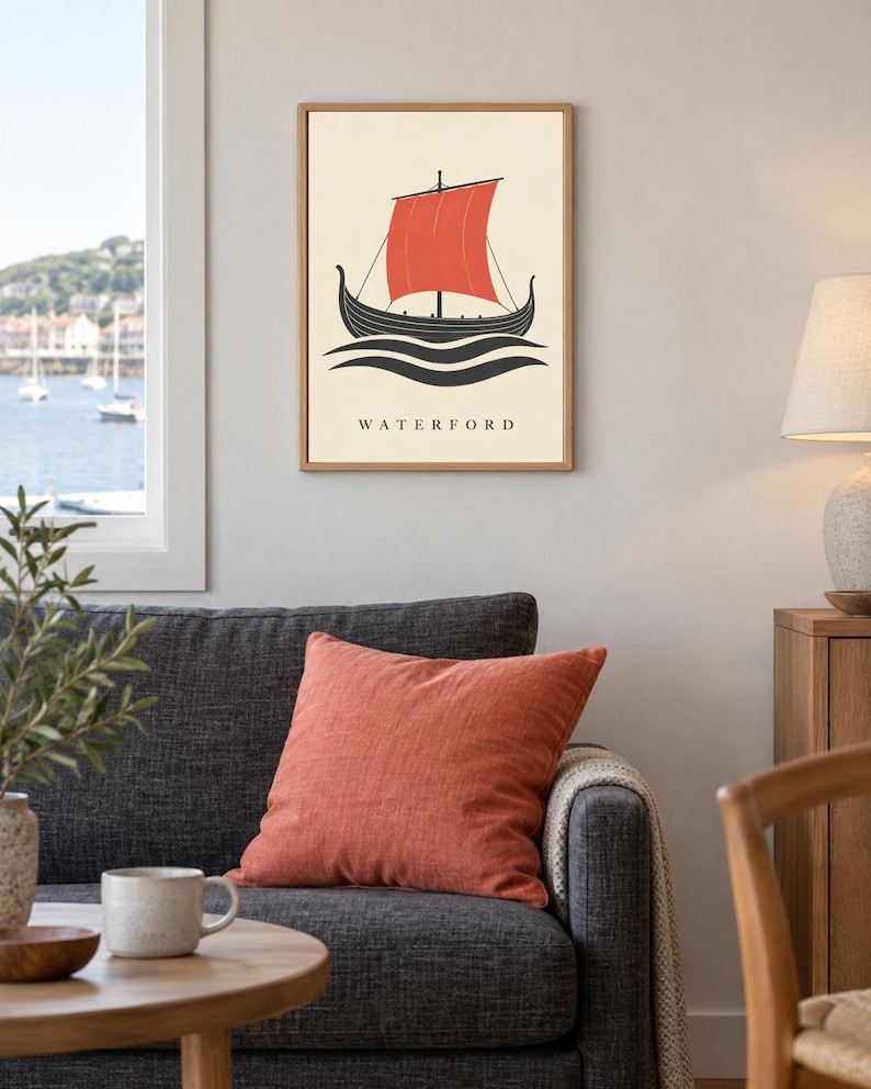 Pode incluir: Uma impress&atilde;o art&iacute;stica emoldurada com um navio viking preto estilizado com uma vela vermelha vibrante, navegando sobre ondas pretas num fundo creme. A palavra WATERFORD est&aacute; impressa em letras mai&uacute;sculas pretas na parte inferior.
