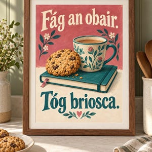 Pu&ograve; includere: Una stampa artistica incorniciata raffigurante un biscotto con gocce di cioccolato su un libro verde acqua accanto a una tazza a motivi floreali. Il testo recita F&aacute;g an obair. T&oacute;g briosca. Lo sfondo &egrave; diviso tra rosso spento e crema.