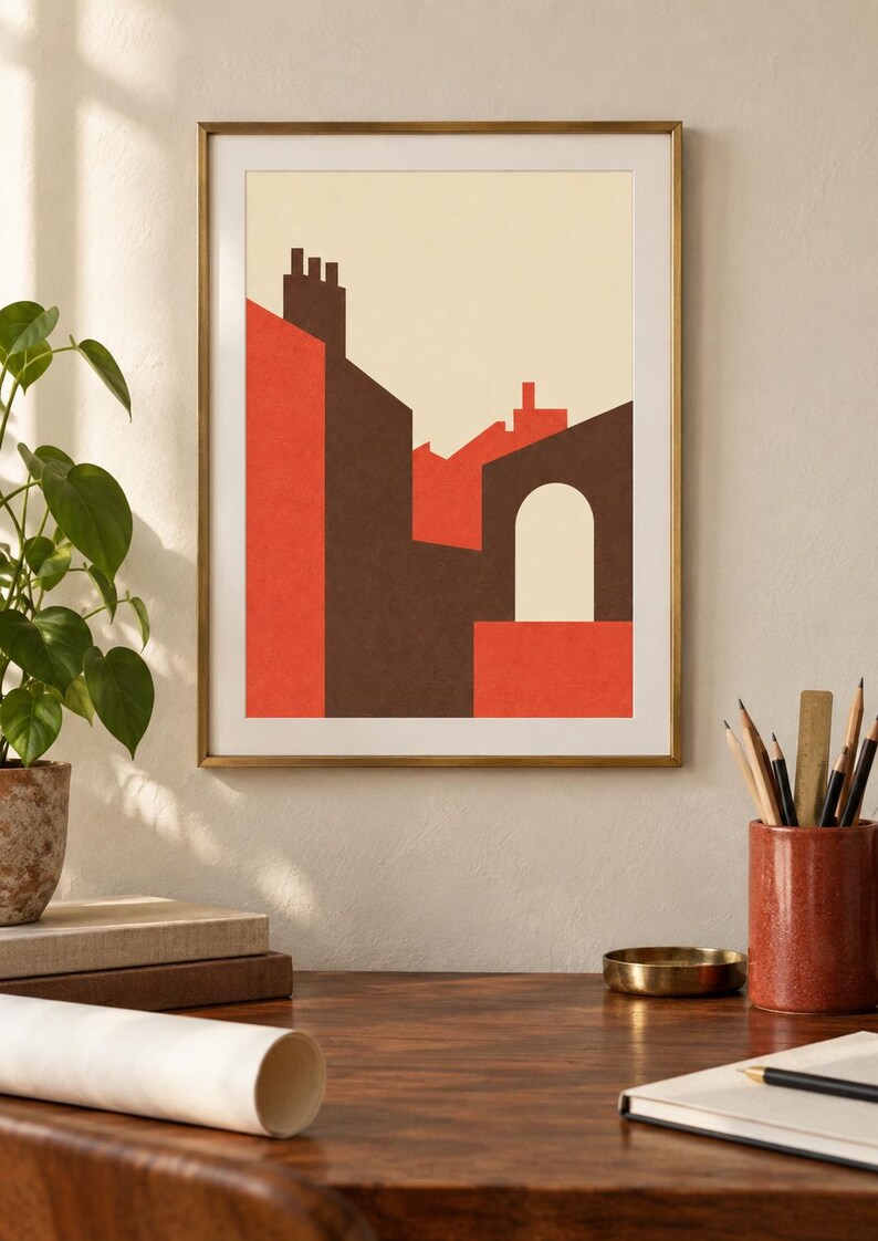 K&ouml;nnte beinhalten: Ein gerahmter Wandkunstdruck mit einer geometrischen Architekturillustration von Geb&auml;uden in den Farben Dunkelbraun, leuchtendes Orange und Creme. Die Komposition zeigt stilisierte D&auml;cher, Schornsteine und einen einzelnen Torbogen vor einem hellen Hintergrund.