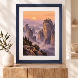 Pu&ograve; includere: Una stampa d'arte incorniciata che raffigura un paesaggio di alti pilastri rocciosi che si ergono sopra una valle nebbiosa al tramonto. La scena include un piccolo edificio in cima alla vetta pi&ugrave; alta, circondato da alberi, sotto un cielo arancione.