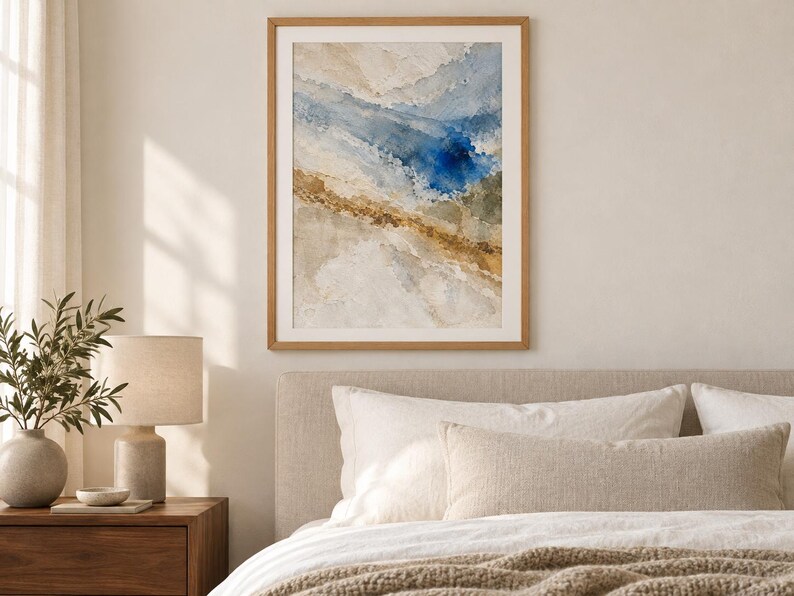 Puede incluir: Una impresi&oacute;n de arte mural abstracto enmarcada que presenta pinceladas texturizadas en tonos azul profundo, beige arena y blanco apagado. La obra de arte est&aacute; encerrada en un marco de madera de tono claro, mostrando una composici&oacute;n de colores.