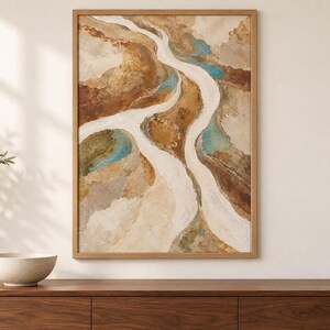 Pu&ograve; includere: Un'opera d'arte da parete rettangolare incorniciata raffigurante un dipinto paesaggistico astratto con sentieri bianchi fluidi che si snodano attraverso toni della terra strutturati di marrone, beige e marrone chiaro, accentuati da macchie di verde acqua.