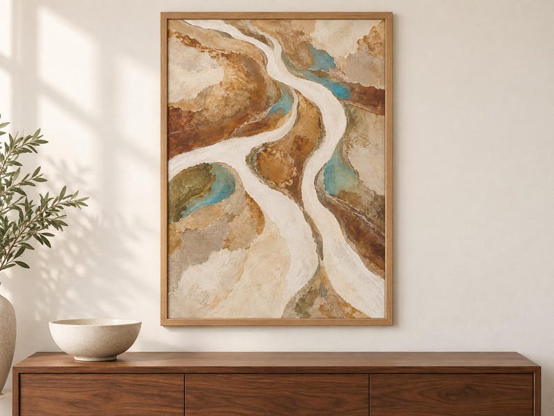 Pu&ograve; includere: Un'opera d'arte da parete rettangolare incorniciata raffigurante un dipinto paesaggistico astratto con sentieri bianchi fluidi che si snodano attraverso toni della terra strutturati di marrone, beige e marrone chiaro, accentuati da macchie di verde acqua.