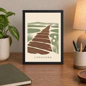 Puede incluir: Una l&aacute;mina enmarcada con una ilustraci&oacute;n estilizada de un sendero de madera marr&oacute;n que serpentea a trav&eacute;s de un pantano verde bajo un cielo crema, con el texto LONGFORD impreso en negro en la parte inferior central de la composici&oacute;n rectangular.
