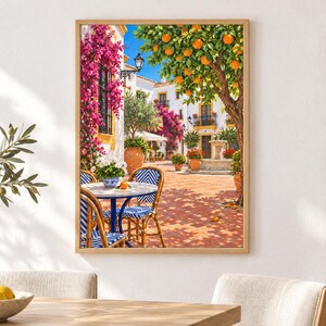 Puede incluir: Una impresi&oacute;n art&iacute;stica enmarcada que representa un patio mediterr&aacute;neo soleado con suelo de terracota, una mesa redonda con sillas azules y blancas, buganvillas rosas vibrantes y un naranjo cargado de frutos naranjas.