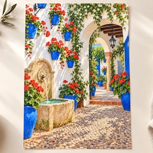 May include: A wall art print depicting a sunlit Mediterranean courtyard with a stone fountain, vibrant red geraniums in bright blue pots, climbing green vines, and a cobblestone path leading through a white arched entryway under a clear sky.