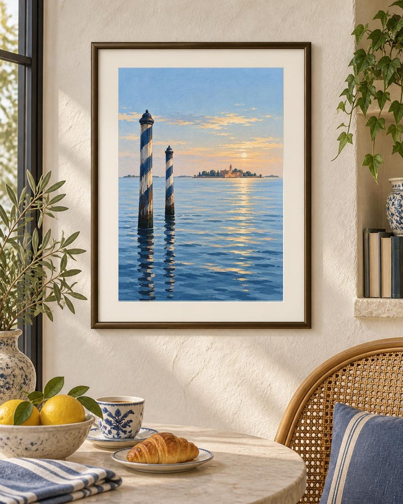 May include: A framed wall art print depicting a serene seascape with two blue and white striped wooden mooring poles rising from calm water. In the distance, a small island with buildings is visible under a soft, golden sunset sky with clouds.