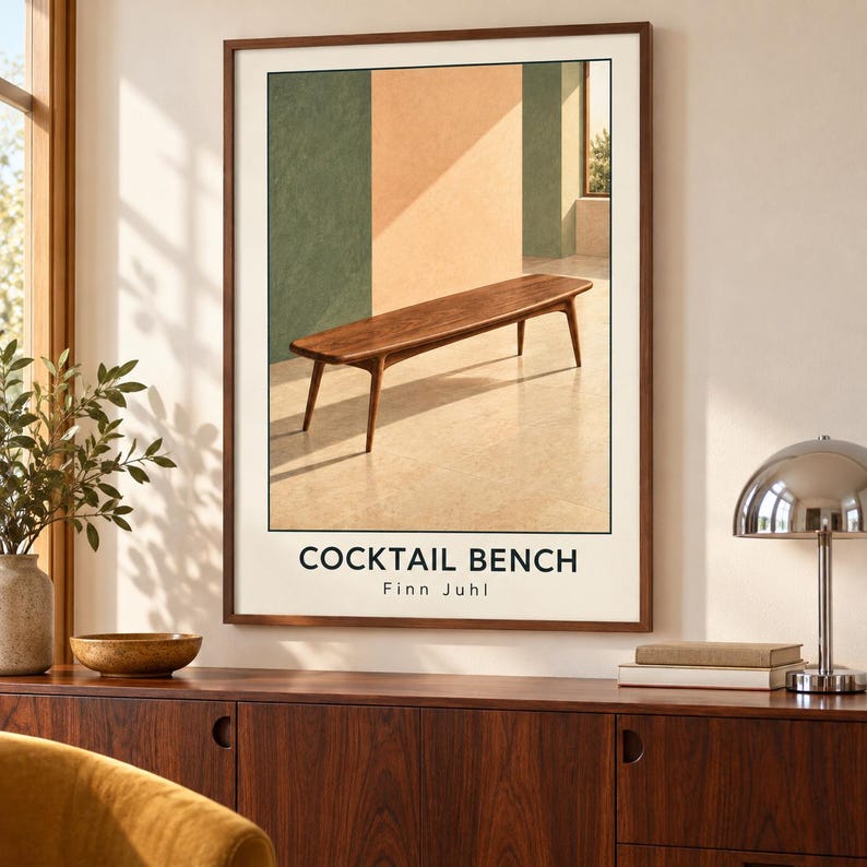 May include: A framed wall art print featuring a wooden bench in a room with green and beige walls. The text COCKTAIL BENCH and Finn Juhl is printed in black at the bottom. The image depicts a wooden bench with four tapered legs on a light floor.