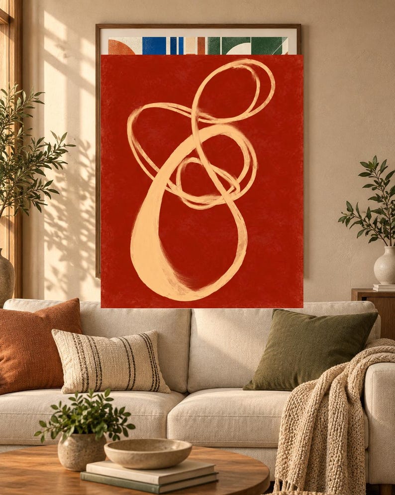 Pode incluir: Uma pe&ccedil;a de arte de parede retangular com um fundo vermelho profundo e uma grande pincelada cont&iacute;nua em bege claro, formando uma forma abstrata, em la&ccedil;o e entrela&ccedil;ada que ocupa o centro da tela vertical.