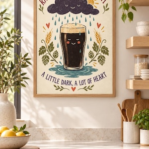 May include: A framed wall art print featuring a dark beer pint with a smiling face, surrounded by hops and wheat. Above is a smiling rain cloud and sun. The text reads: RAIN OR SHINE, HAVE A PINT and A LITTLE DARK, A LOT OF HEART in red and blue.
