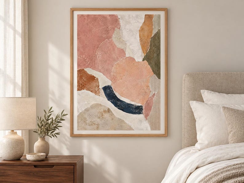 May include: A framed abstract wall art print featuring organic, layered shapes in a palette of dusty pink, terracotta, cream, olive green, and a deep navy blue curved accent. The composition has a textured, collage-like appearance with soft edges.