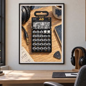 May include: A black Teenage Engineering PO-32 Tonic pocket operator synthesizer featuring a monochrome LCD screen with graphic animations, a grid of sixteen circular buttons, two silver rotary knobs, and the text "tonic" and "pocket operator".