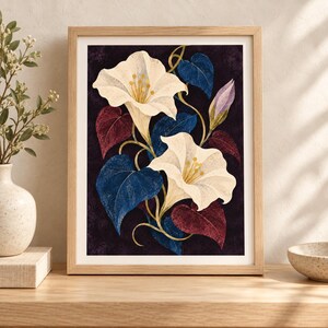 Puede incluir: Una l&aacute;mina de arte enmarcada que muestra dos grandes flores de color crema en forma de trompeta con centros amarillos. La ilustraci&oacute;n bot&aacute;nica incluye hojas en forma de coraz&oacute;n de color azul profundo y granate oscuro, vides doradas y un capullo morado.