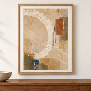 Puede incluir: Una impresi&oacute;n de arte mural abstracto enmarcada que presenta una gran pincelada circular blanca sobre un fondo beige texturizado. La composici&oacute;n incluye bloques rectangulares de terracota, verde oliva y azul profundo, acentuados por tres finas l&iacute;neas negras verticales.