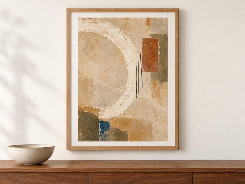 Puede incluir: Una impresi&oacute;n de arte mural abstracto enmarcada que presenta una gran pincelada circular blanca sobre un fondo beige texturizado. La composici&oacute;n incluye bloques rectangulares de terracota, verde oliva y azul profundo, acentuados por tres finas l&iacute;neas negras verticales.