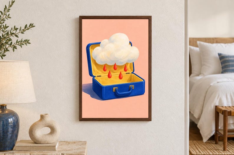 K&ouml;nnte beinhalten: Ein gerahmter Wandkunstdruck mit einem blauen Koffer, der vor einem pfirsichfarbenen Hintergrund offen steht. Im Koffer schwebt eine wei&szlig;e, flauschige Wolke, aus der mehrere leuchtend rote Tropfen in den leeren unteren Teil fallen.