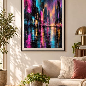 May include: A framed vertical wall art print depicting a vibrant city street scene at night. The composition features tall buildings with glowing neon pink, electric blue, and warm orange lights reflecting on a wet, dark ground surface.