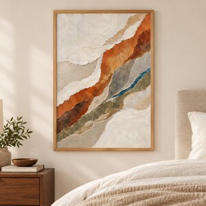 May include: A framed vertical wall art piece featuring an abstract composition of layered, torn-paper style textures in shades of burnt orange, deep brown, muted olive green, slate gray, and cream, accented by a thin, vibrant blue vertical line.