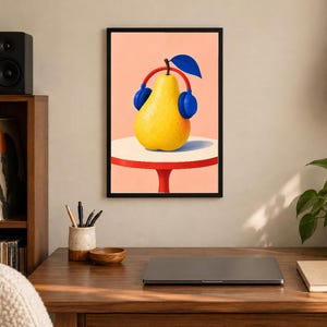 May include: A framed wall art print featuring a yellow pear wearing blue headphones, set against a light peach background. The pear rests on a white circular table with a red base. The illustration uses bold colours and clean lines to depict the fruit.