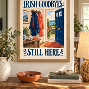 K&ouml;nnte beinhalten: Ein gerahmter Kunstdruck mit dem Text IRISH GOODBYES: STILL HERE. Die Illustration zeigt eine offene blaue T&uuml;r mit Blick auf eine K&uuml;stenlandschaft, M&auml;ntel an einer Garderobe, eine Holzbank und einen Korb in einem hellen Eingangsbereich.