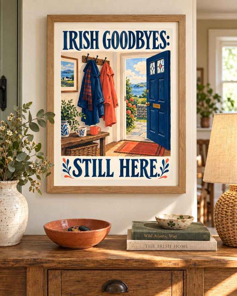 K&ouml;nnte beinhalten: Ein gerahmter Kunstdruck mit dem Text IRISH GOODBYES: STILL HERE. Die Illustration zeigt eine offene blaue T&uuml;r mit Blick auf eine K&uuml;stenlandschaft, M&auml;ntel an einer Garderobe, eine Holzbank und einen Korb in einem hellen Eingangsbereich.