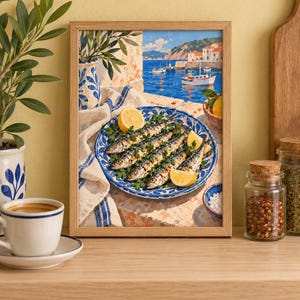 May include: A framed art print depicting a coastal scene with a blue and white patterned plate holding grilled sardines garnished with parsley and lemon wedges. The background shows a Mediterranean harbour with boats on blue water and white buildings.