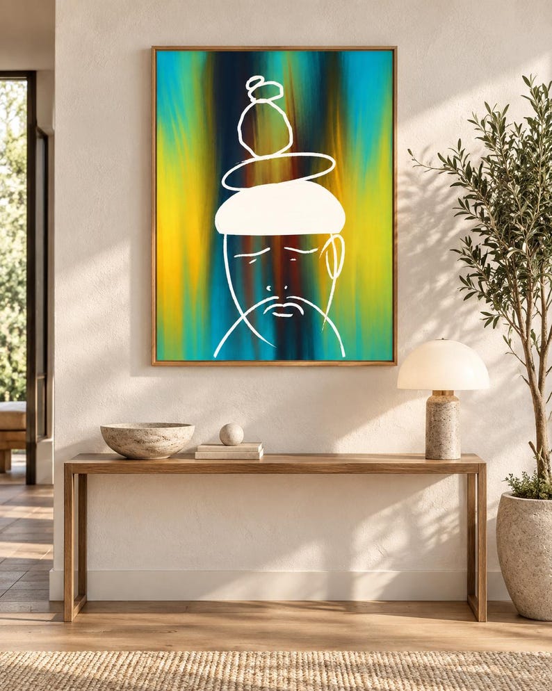 May include: A rectangular framed wall art piece featuring a vibrant vertical gradient background of blue, yellow, and dark brown. A white line drawing of a face with a stacked stone-like shape on top is centered on the canvas within a wooden frame.