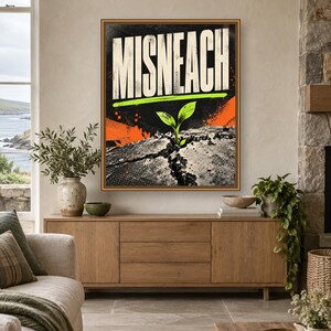 May include: A rectangular wall art print featuring the word MISNEACH in large white capital letters. Below the text, a small green sprout emerges from a cracked, textured gray surface. The background includes orange and black graphic accents.