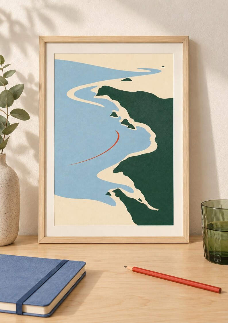 May include: A framed wall art print featuring a stylized coastal landscape with a light blue ocean, beige sandy shoreline, and dark green landmasses. A thin, curved red line is positioned in the water. The print is enclosed in a light wood frame.
