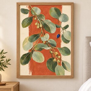 May include: A framed wall art print featuring a botanical illustration of a leafy branch with green foliage and small pale yellow buds against a vertical burnt orange stripe on a cream background, with one single small blue berry visible.