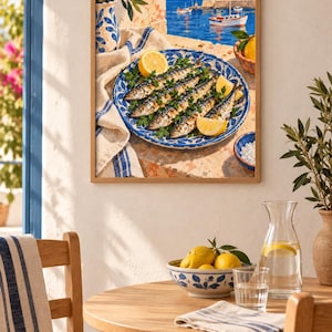 May include: A framed wall art print depicting a Mediterranean scene with a blue and white patterned plate of grilled sardines garnished with parsley and lemon wedges, set against a coastal harbour background with boats and white buildings.