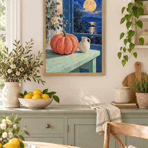 Pode incluir: Uma impress&atilde;o de arte de parede emoldurada retratando uma ab&oacute;bora laranja vibrante e um pequeno jarro branco sobre uma mesa azul-clara. A cena &eacute; definida contra uma janela com vista para um c&eacute;u noturno azul-escuro, uma lua cheia e o litoral.