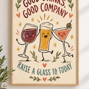 May include: A framed wall art print featuring a cartoon wine glass, beer glass, and martini glass with faces. The text reads "GOOD DRINKS, GOOD COMPANY" and "RAISE A GLASS TO TODAY" in red and blue. The background is cream with small orange hearts and stars.