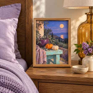 May include: A rectangular framed print featuring a landscape painting of a moonlit coastal scene at night. The artwork depicts a turquoise wooden table holding a purple bowl, two small pumpkins, and a draped lavender cloth against a Mediterranean backdrop.