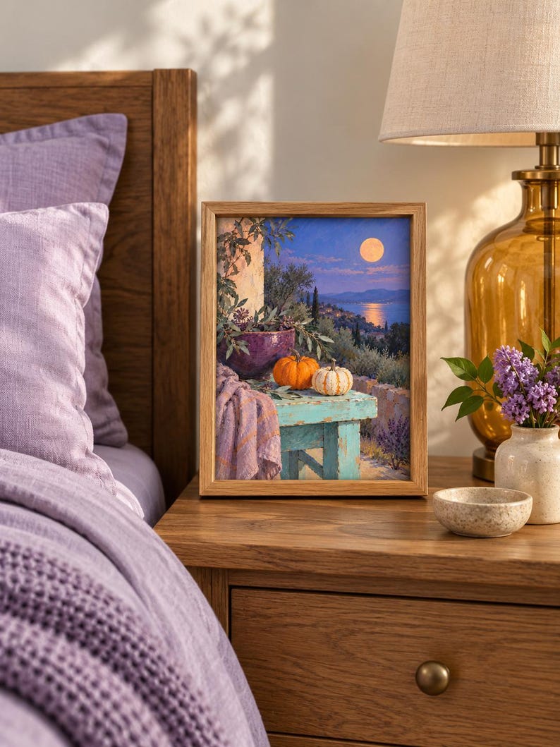May include: A rectangular framed print featuring a landscape painting of a moonlit coastal scene at night. The artwork depicts a turquoise wooden table holding a purple bowl, two small pumpkins, and a draped lavender cloth against a Mediterranean backdrop.