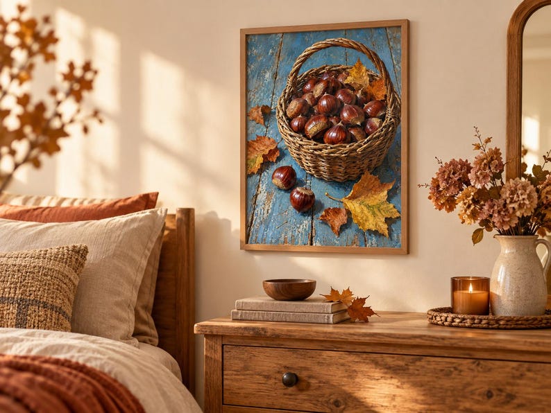 May include: A framed wall art print featuring a woven basket filled with brown chestnuts resting on a weathered blue wooden surface, accompanied by scattered autumn leaves in shades of orange and yellow, capturing a seasonal harvest theme.