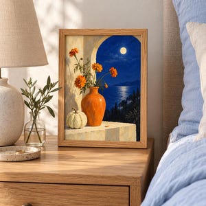 Puede incluir: Una l&aacute;mina enmarcada que representa un bodeg&oacute;n con un jarr&oacute;n naranja que contiene flores de cal&eacute;ndula naranjas y una peque&ntilde;a calabaza blanca sobre una repisa, frente a una vista nocturna de un mar iluminado por la luna.