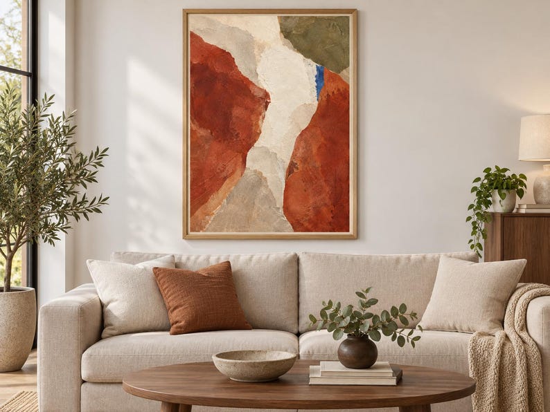May include: A rectangular wall art piece in a light wood frame featuring an abstract composition with large, textured blocks of deep terracotta red, creamy off-white, muted olive green, and a small vertical accent of bright blue paint.