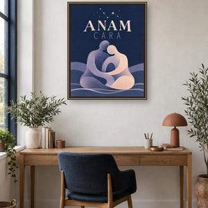 May include: A rectangular wall art print in a dark frame featuring the text ANAM CARA in cream lettering. Below the text, two stylized figures in shades of purple and peach are depicted in an embrace against a dark blue background with stars.
