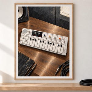 May include: A white portable synthesiser with a keyboard, multiple black circular buttons, and four coloured knobs in blue, yellow, grey, and orange. The device features a small screen, a speaker grille, and the text OP-1 printed on the right side.