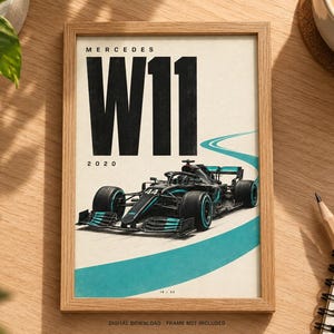 May include: A framed poster featuring a black Mercedes W11 Formula 1 race car with teal accents on a white background. The text reads MERCEDES W11 2020. A curved teal track line is visible behind the car. The frame is light wood.