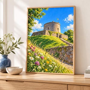 Puede incluir: Una impresi&oacute;n de arte mural enmarcada que representa una torre de piedra sobre una colina cubierta de hierba bajo un cielo azul brillante. El primer plano presenta un prado vibrante lleno de margaritas blancas, flores amarillas y tr&eacute;boles.