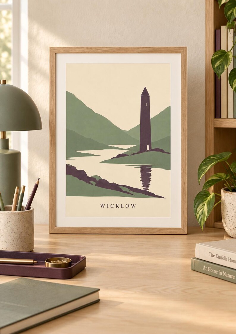 Peut inclure: Une impression d'art encadr&eacute;e pr&eacute;sentant une illustration paysag&egrave;re stylis&eacute;e d'une haute tour violet fonc&eacute; situ&eacute;e pr&egrave;s d'une rivi&egrave;re et de collines vertes, avec le texte WICKLOW imprim&eacute; en noir au centre inf&eacute;rieur du fond cr&egrave;me.