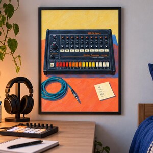 Op de afbeelding: Een ingelijste kunstdruk met een zwarte Roland TR-808 Rhythm Composer drumcomputer met een rij kleurrijke stappentoetsen, een opgerolde blauwe audiokabel en een klein geel memoblaadje met handgeschreven tekst op een oranje en gele achtergrond.