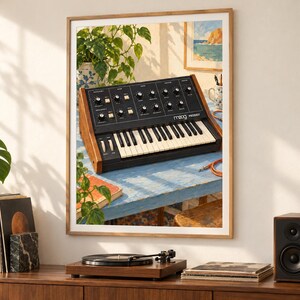 May include: A framed wall art print depicting a Moog Prodigy analog synthesizer with a black control panel, white keys, and wooden side panels, resting on a light blue table in a sunlit room with green plants and a coastal painting in the background.