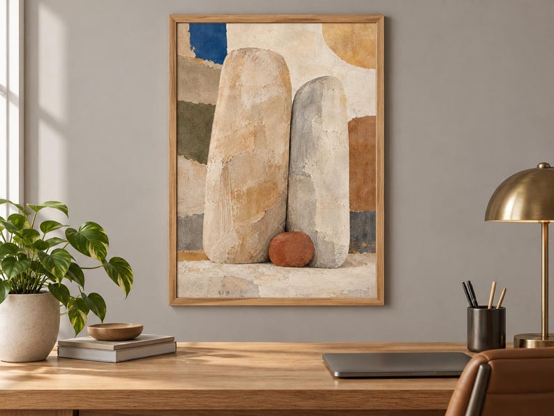 May include: A framed wall art print featuring an abstract composition of two large, textured, light-colored vertical stone-like shapes and one small, round, reddish-brown stone at their base, set against a background of muted blue, green, and tan blocks.