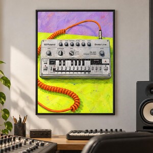 May include: A framed art print featuring a silver Roland TB-303 Bass Line synthesizer with a coiled orange cable, set against a vibrant lime green and purple painted background. The device displays various knobs, switches, and a small keyboard.